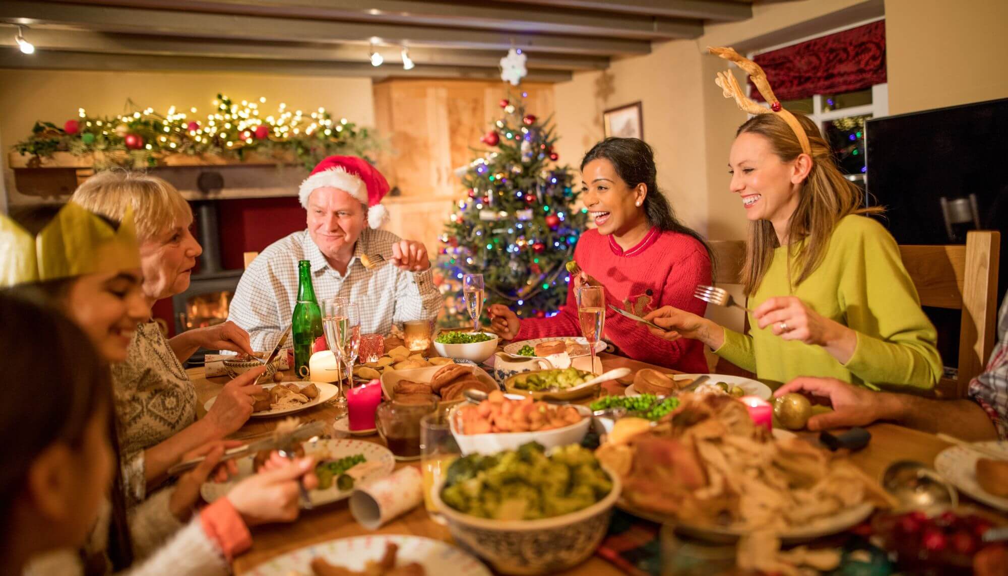 A family seated around a dining table enjoying a traditional Christmas feast.