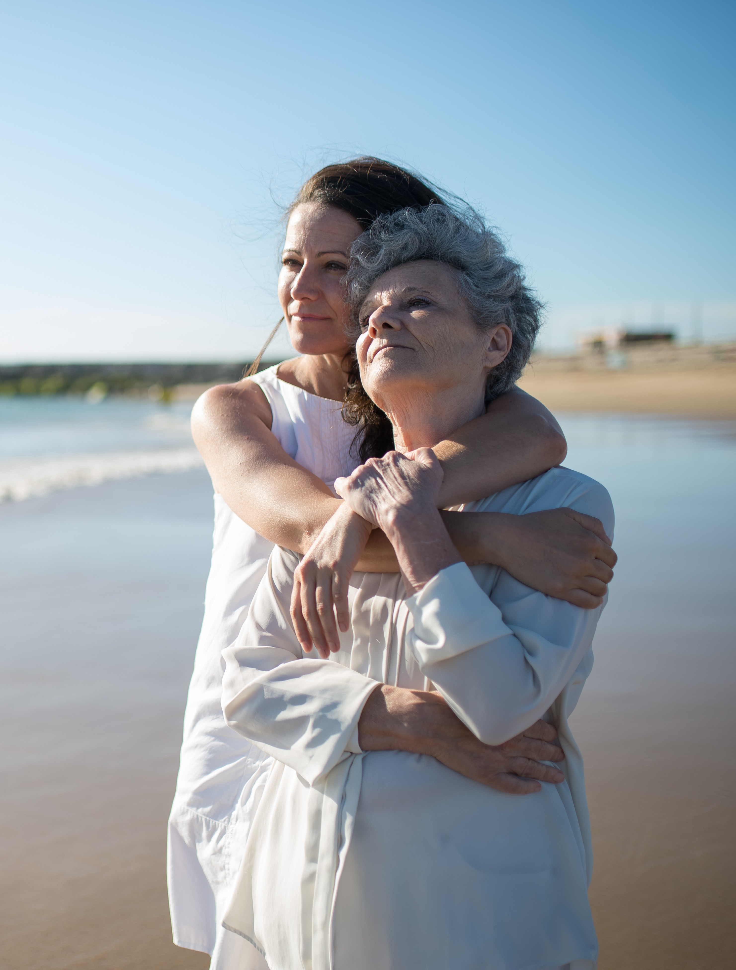 A lady hugs her mother on the beach