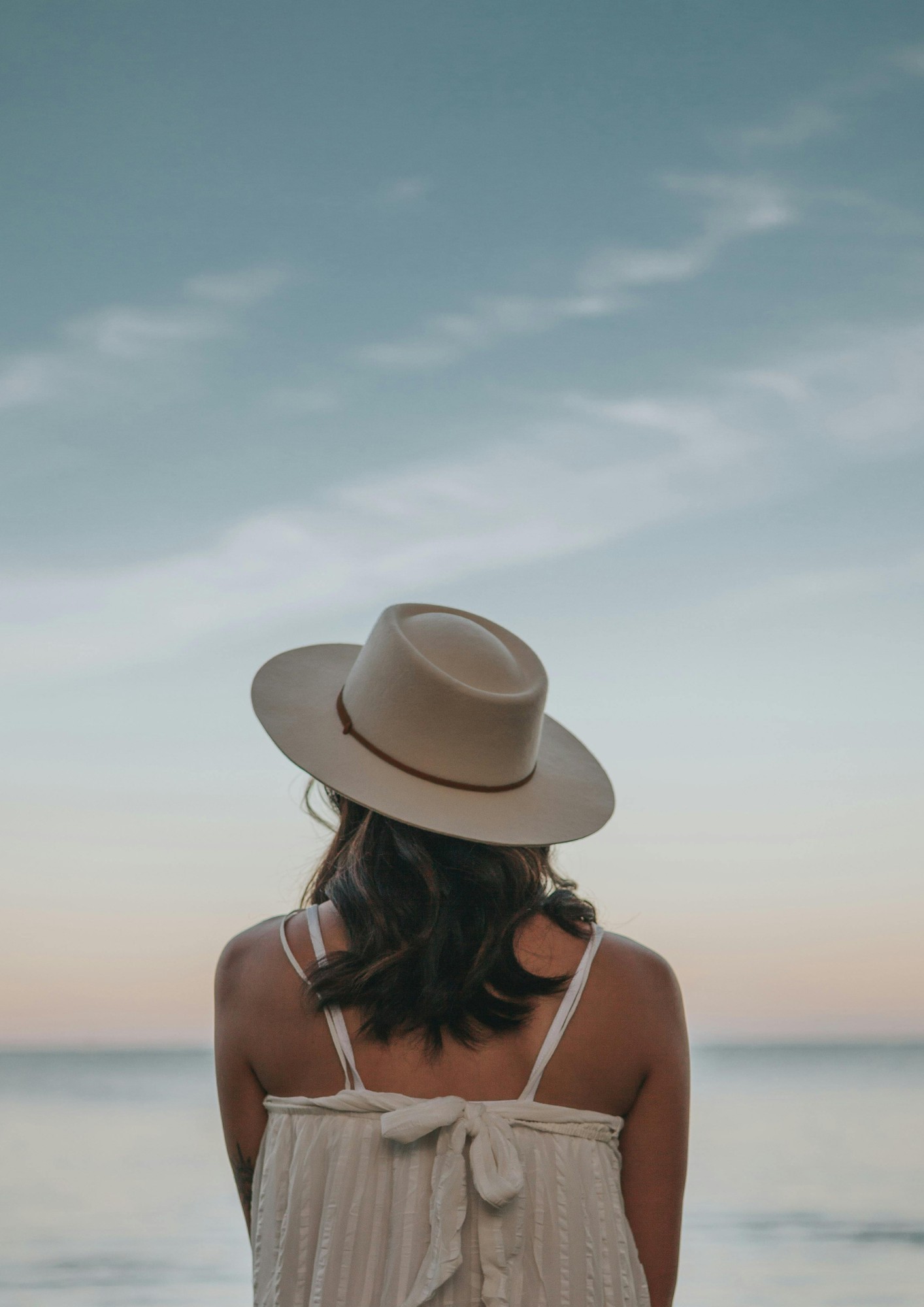 A woman's back facing the sea