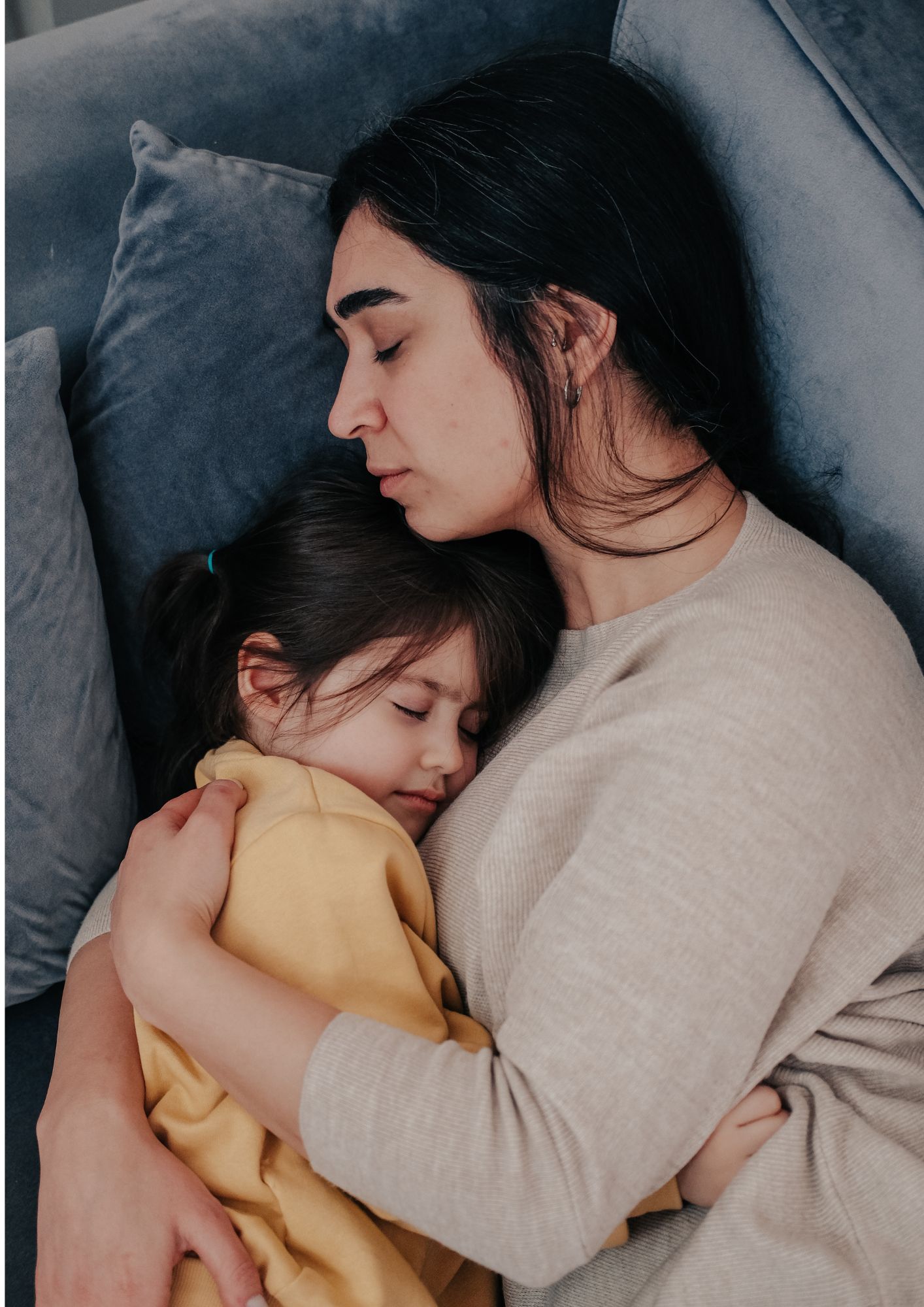A mother and child sleep in each other's arms