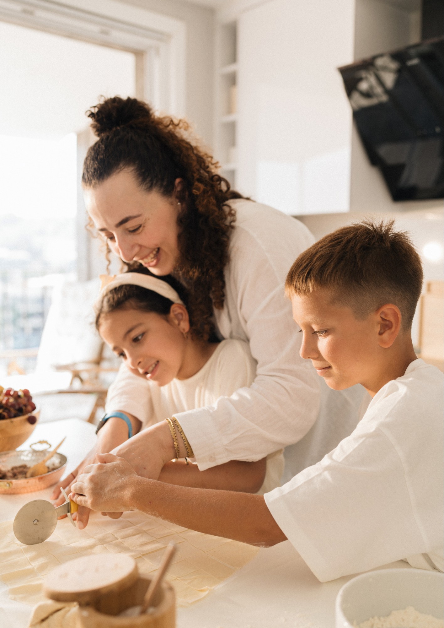 Two kids cook with their mother