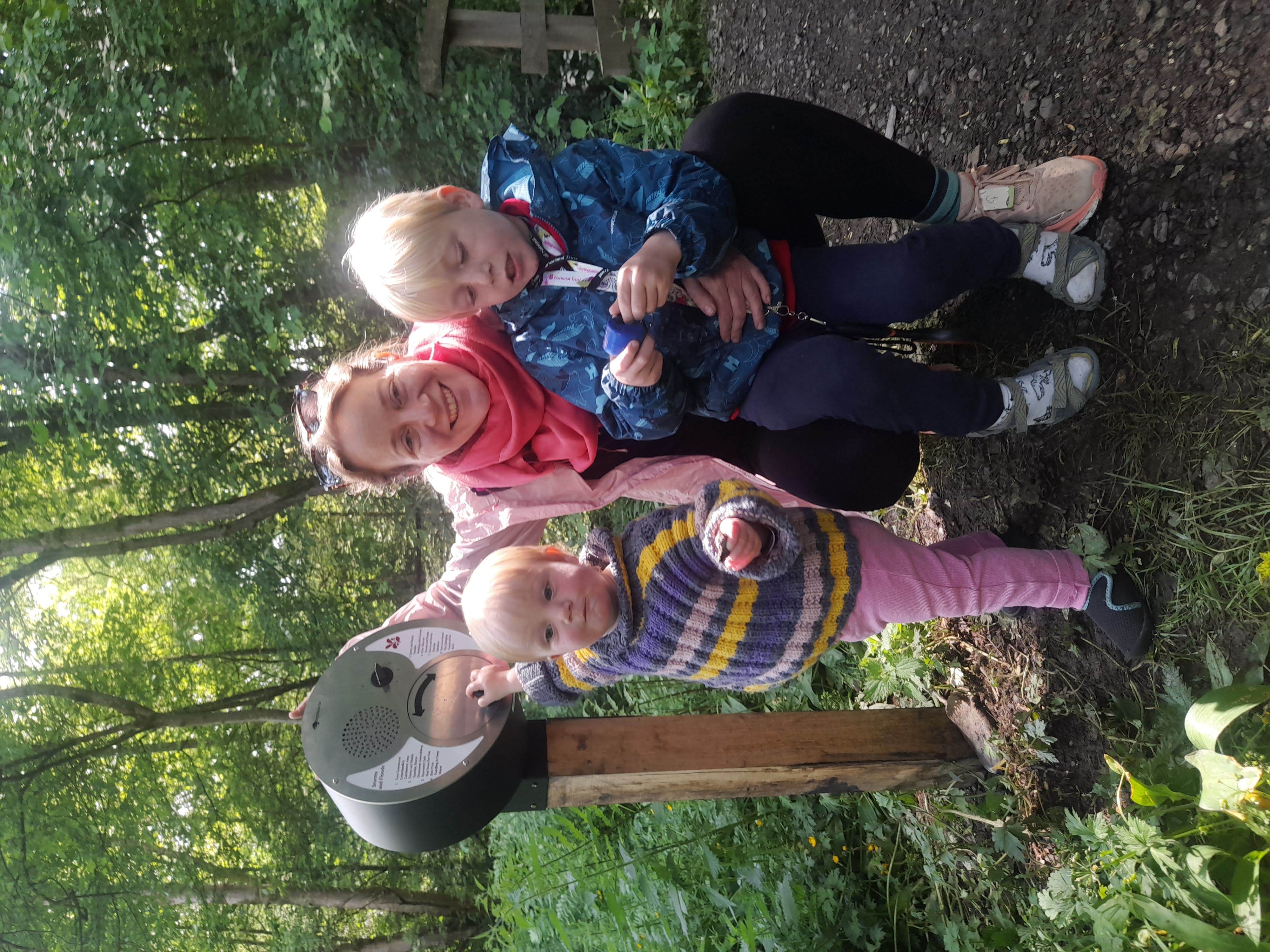 A mother and children crouch by a sign