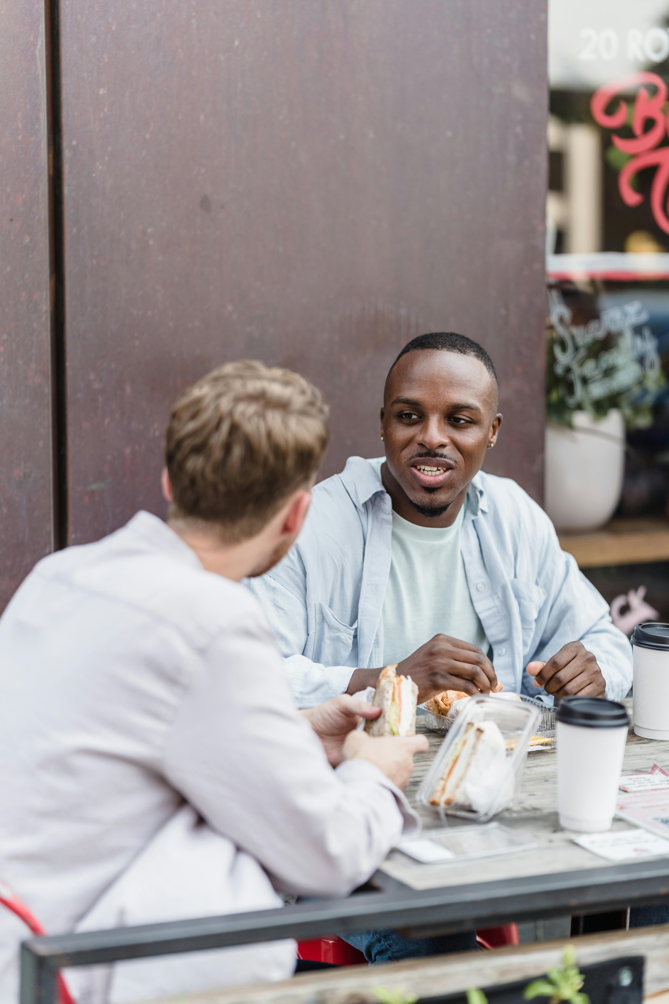 Two men chat outside a cafe