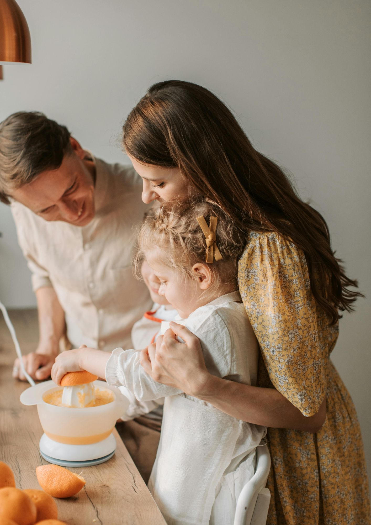 A family of three make orange juice together