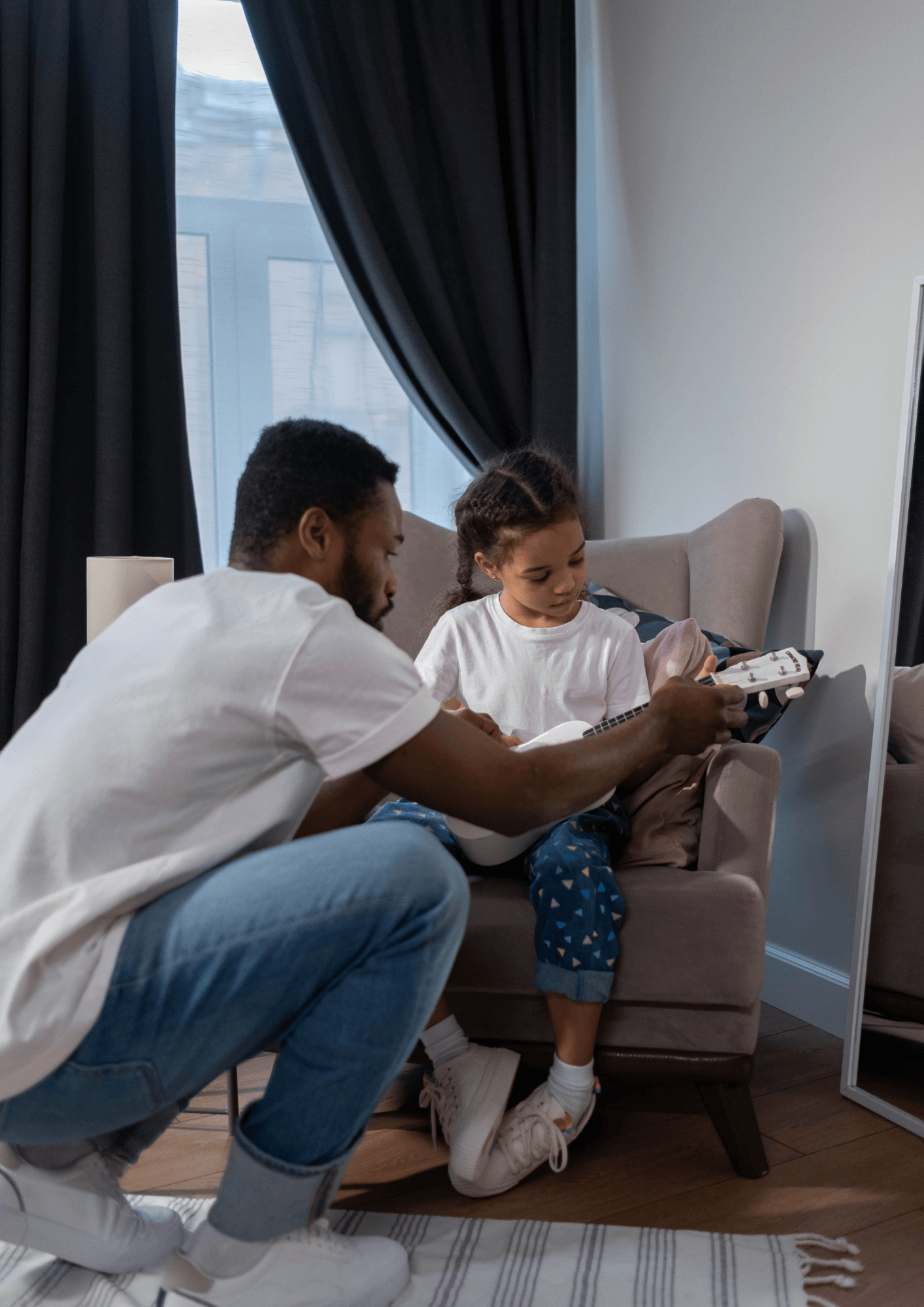 A father teaching his daughter how to play guitar