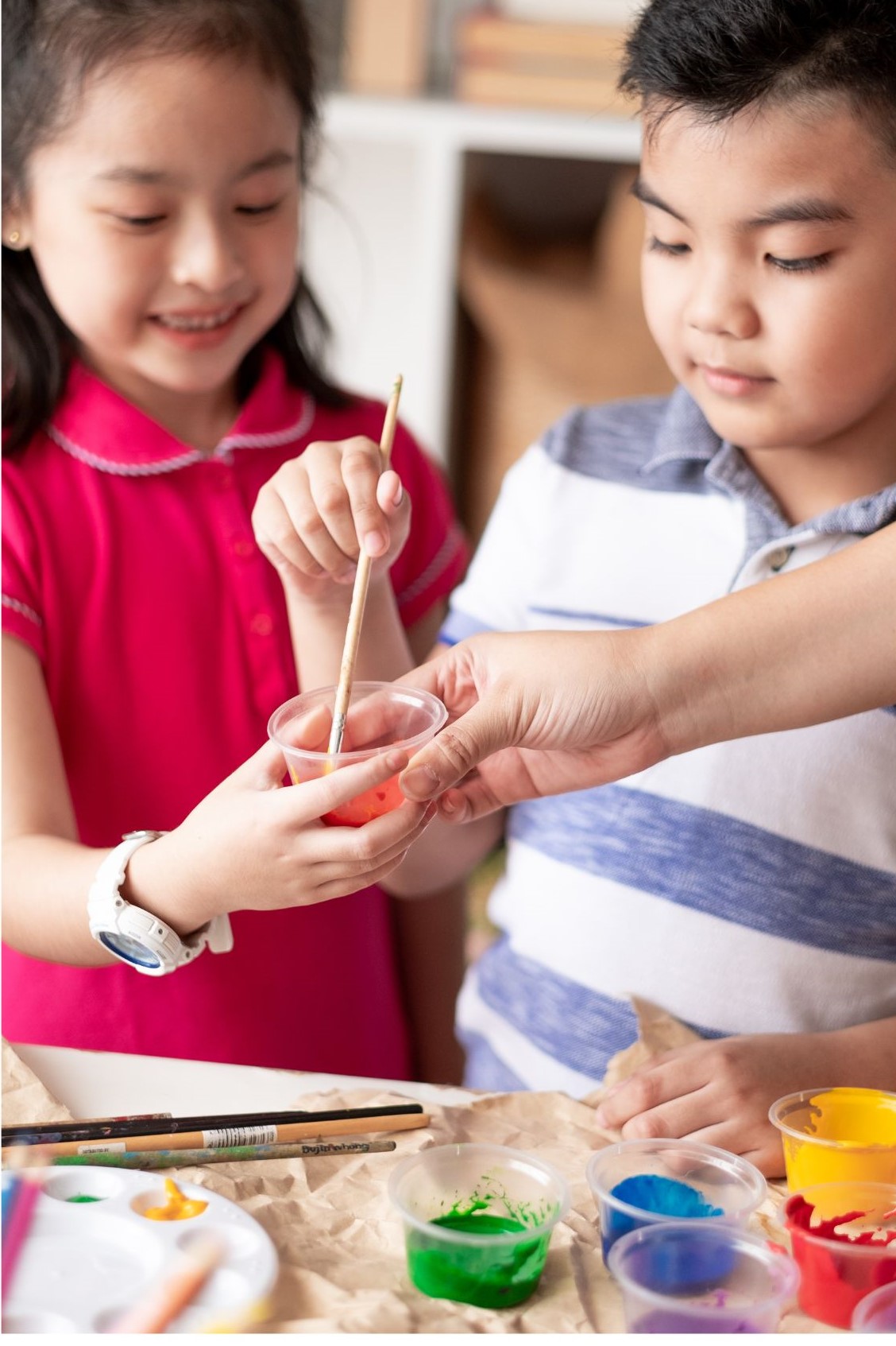 Two children mix paint.