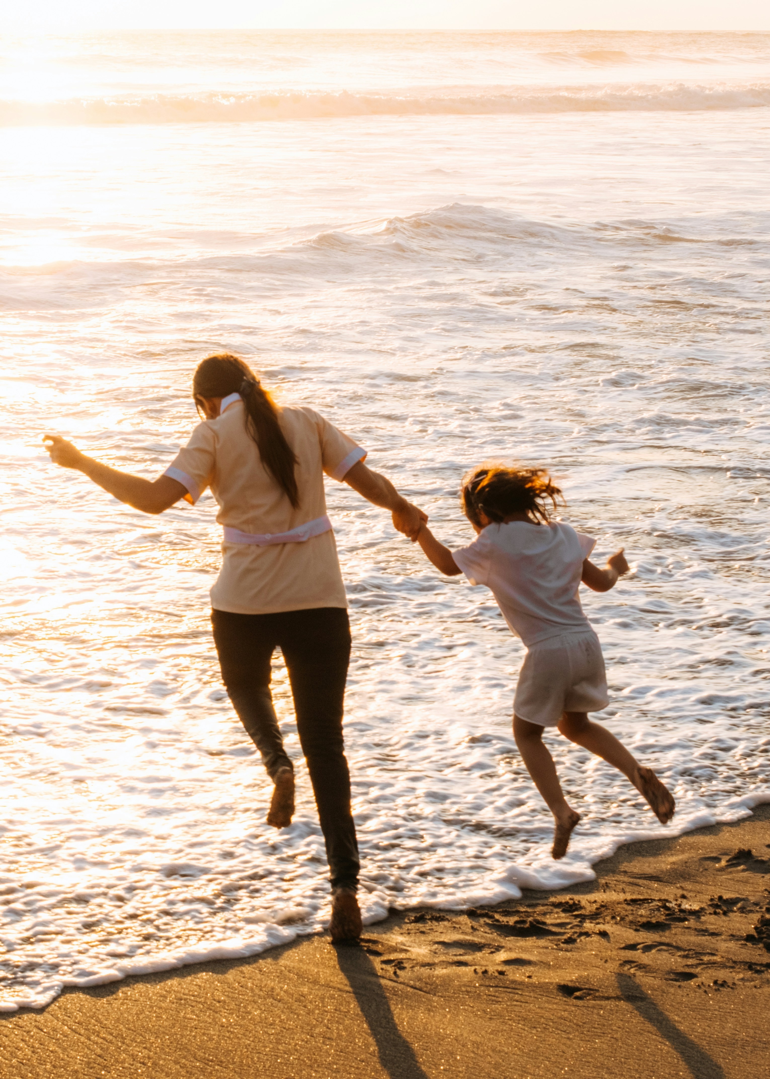 A mother and daughter run into the sea