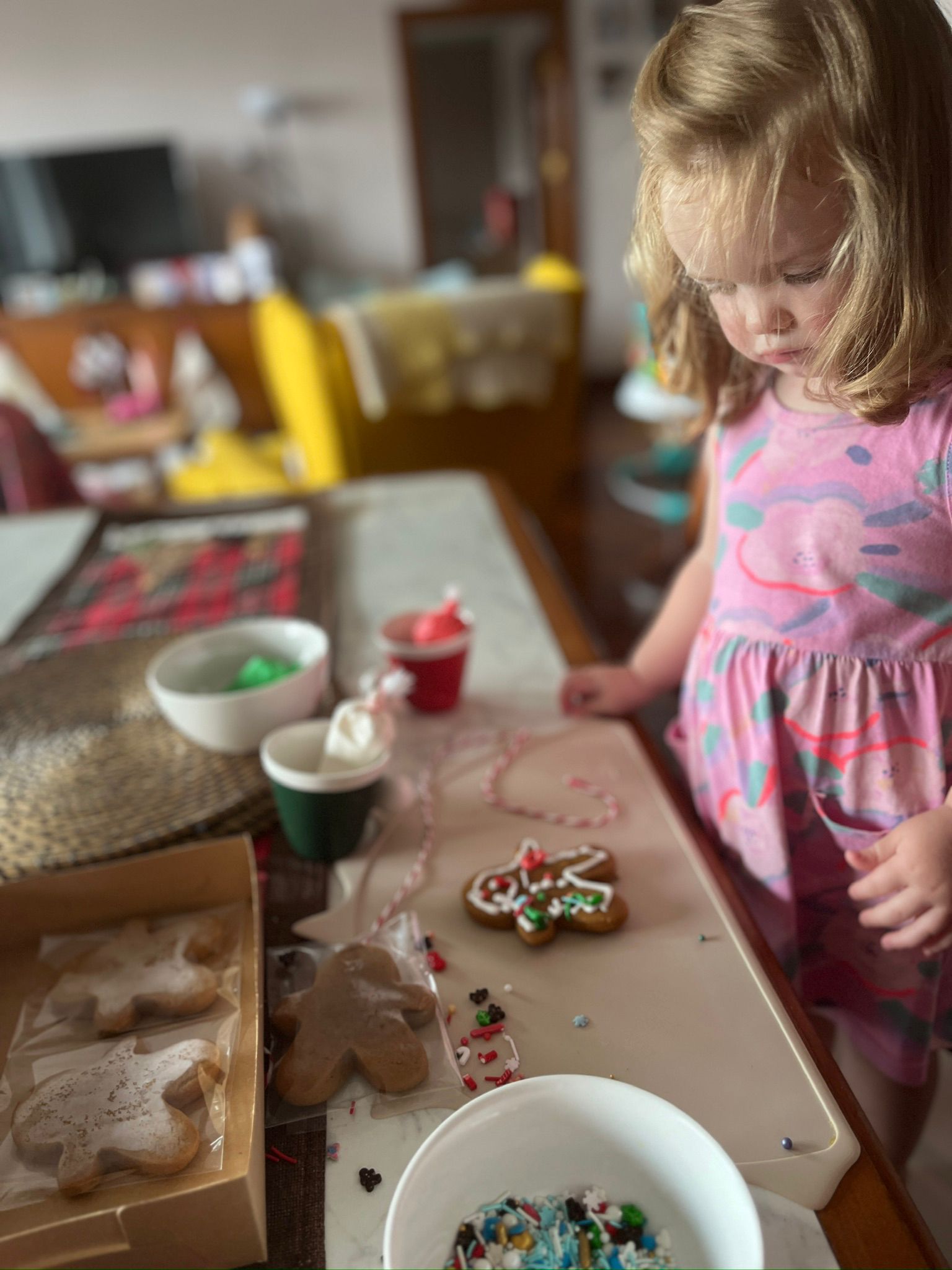 A white toddler decorates cookies