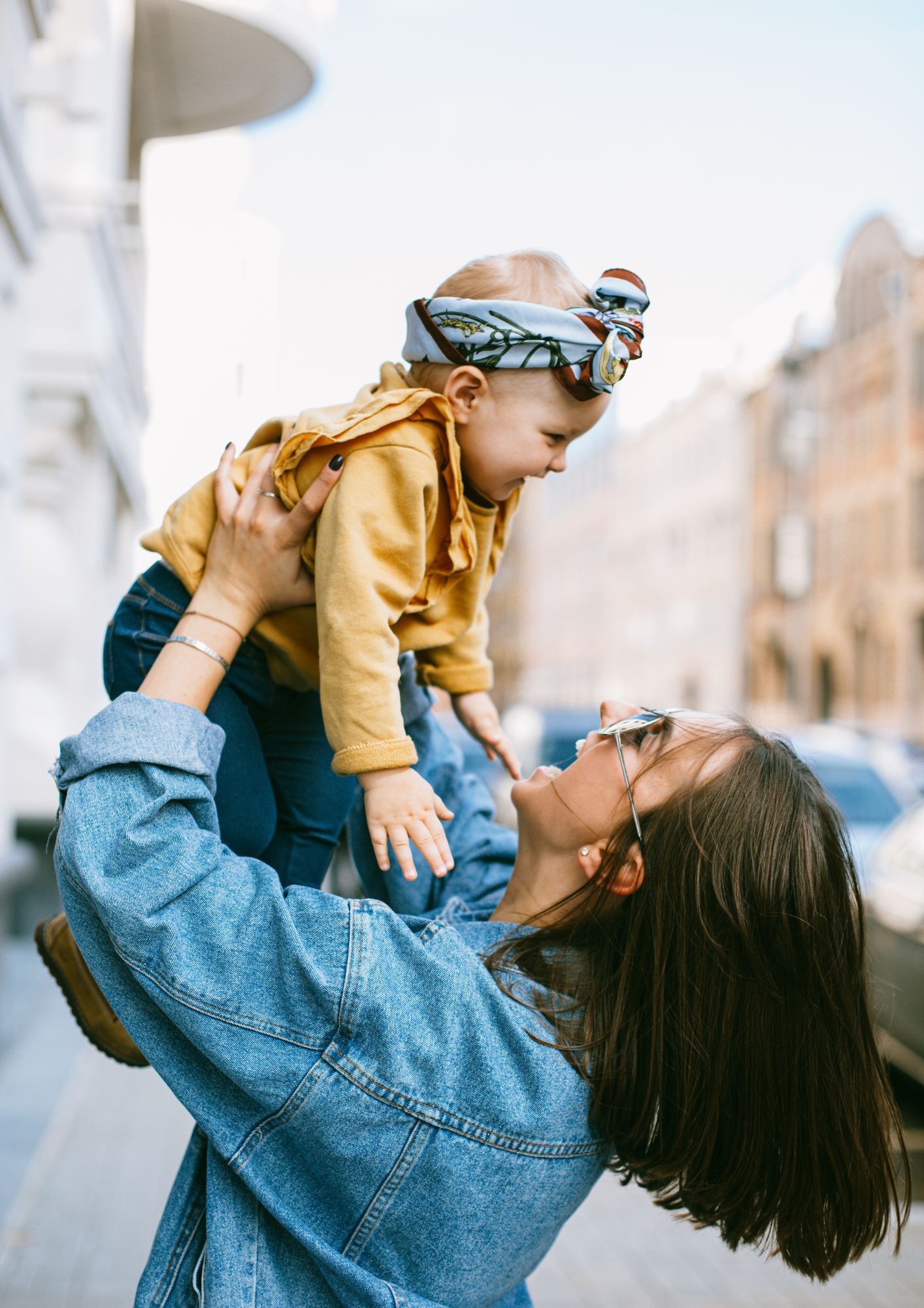 A mother holds her child high in the air