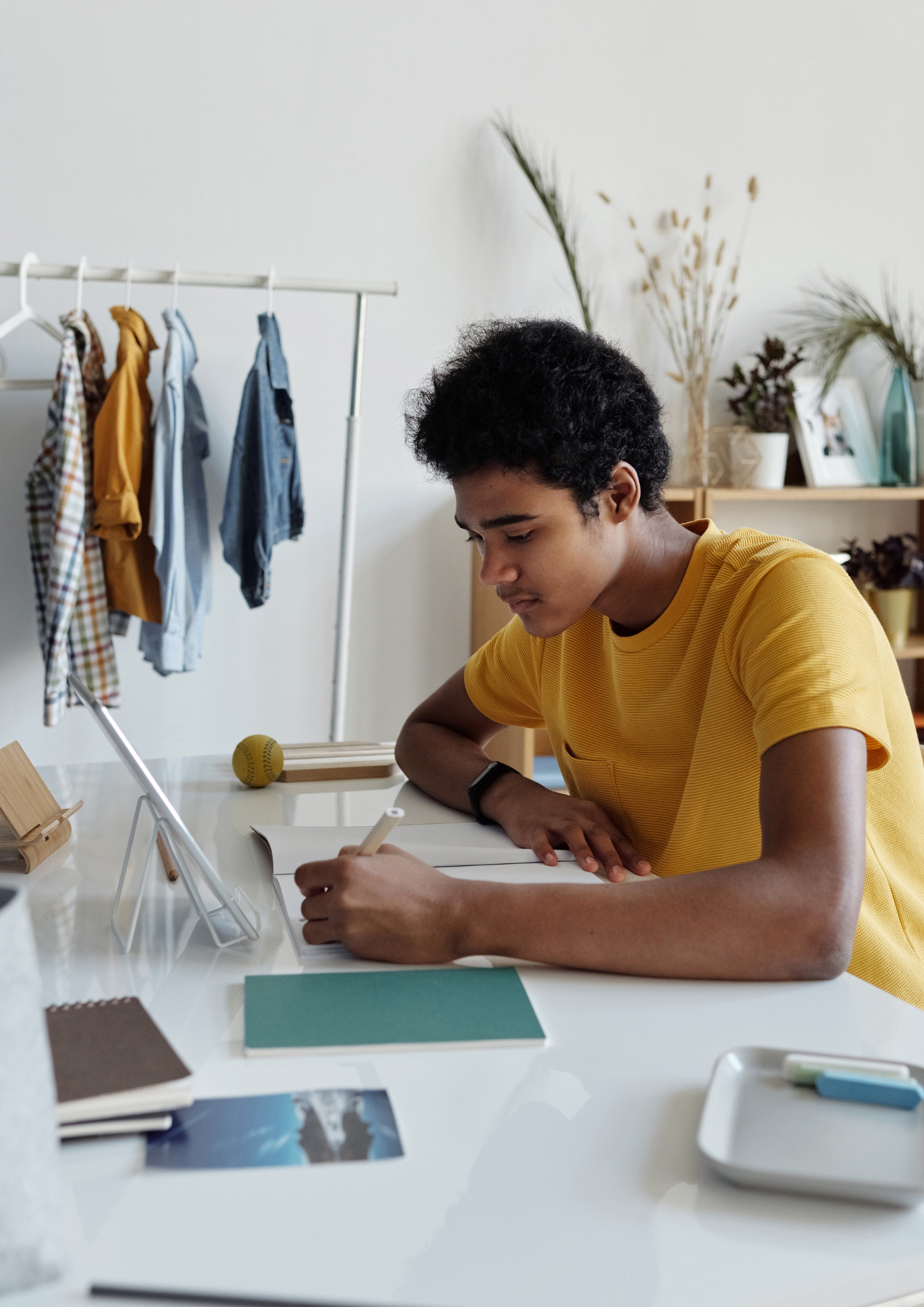 A Black teen boy studies at his desk