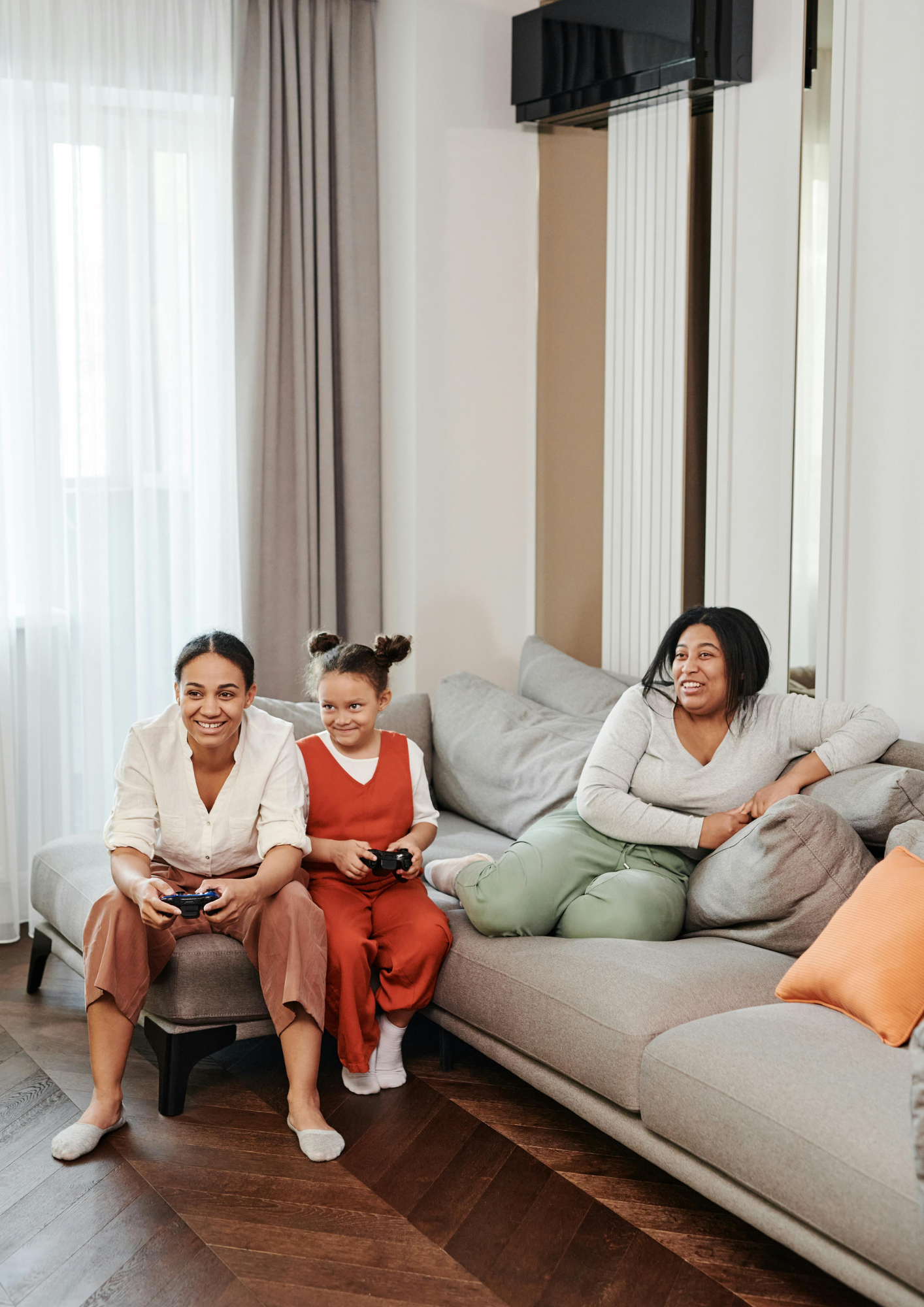 A family play a computer game sat on the couch