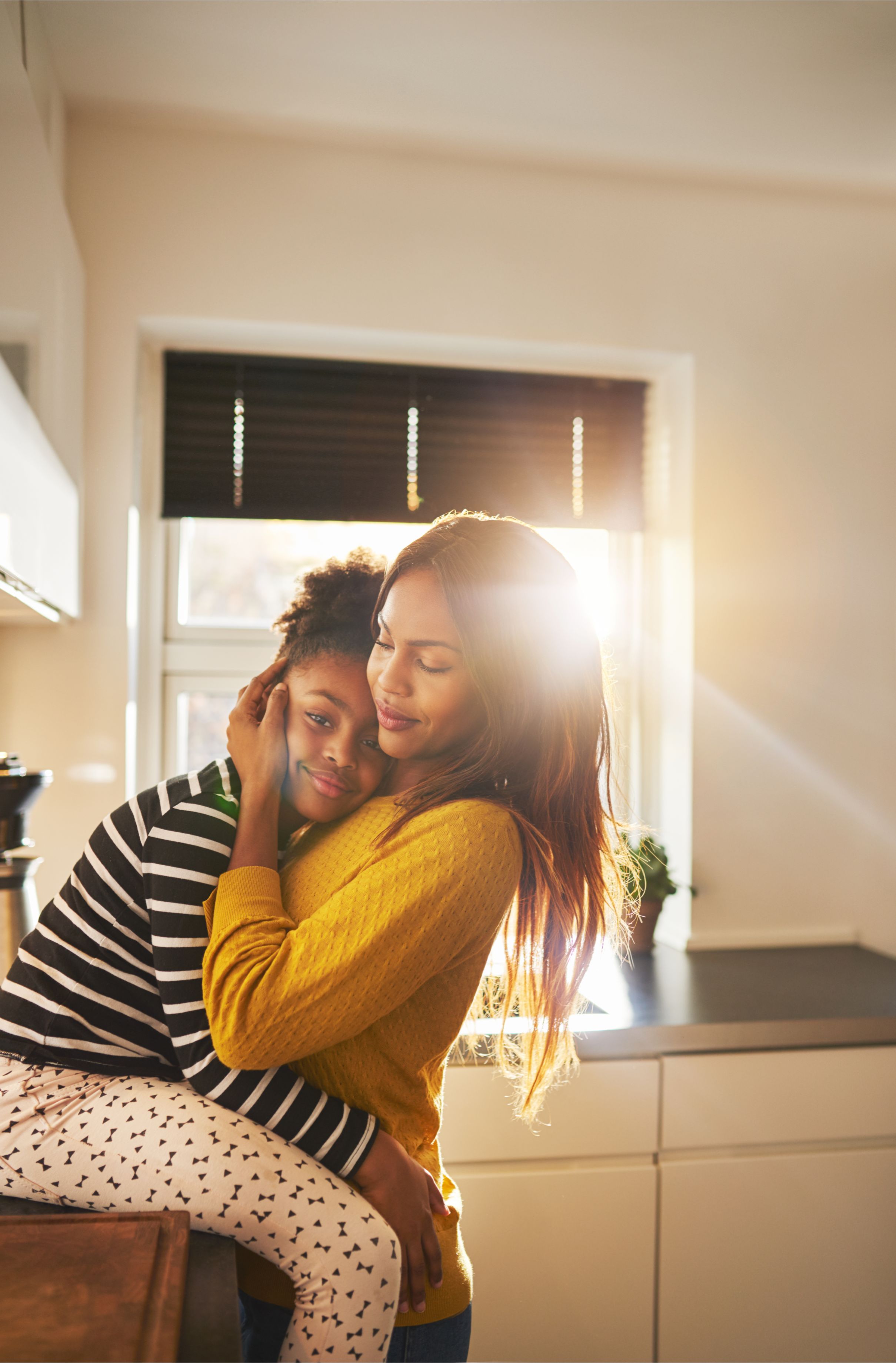 A Black mother and daughter hugging