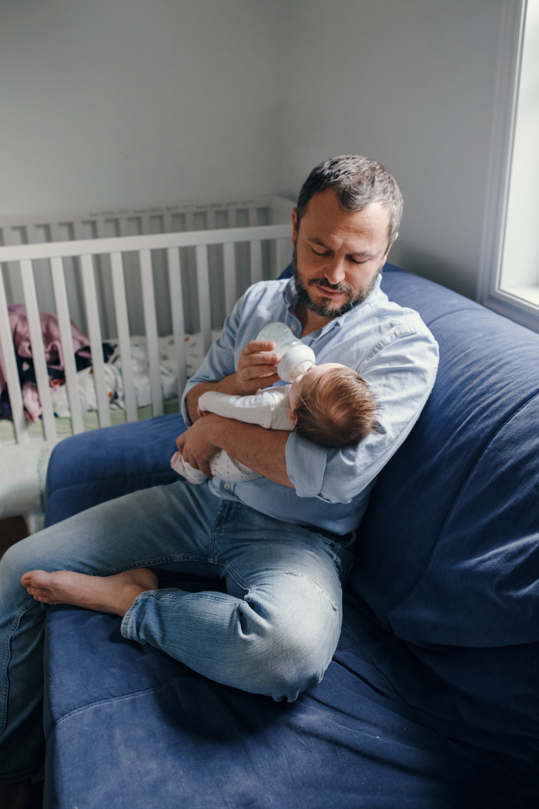 A father feeding his newborn baby