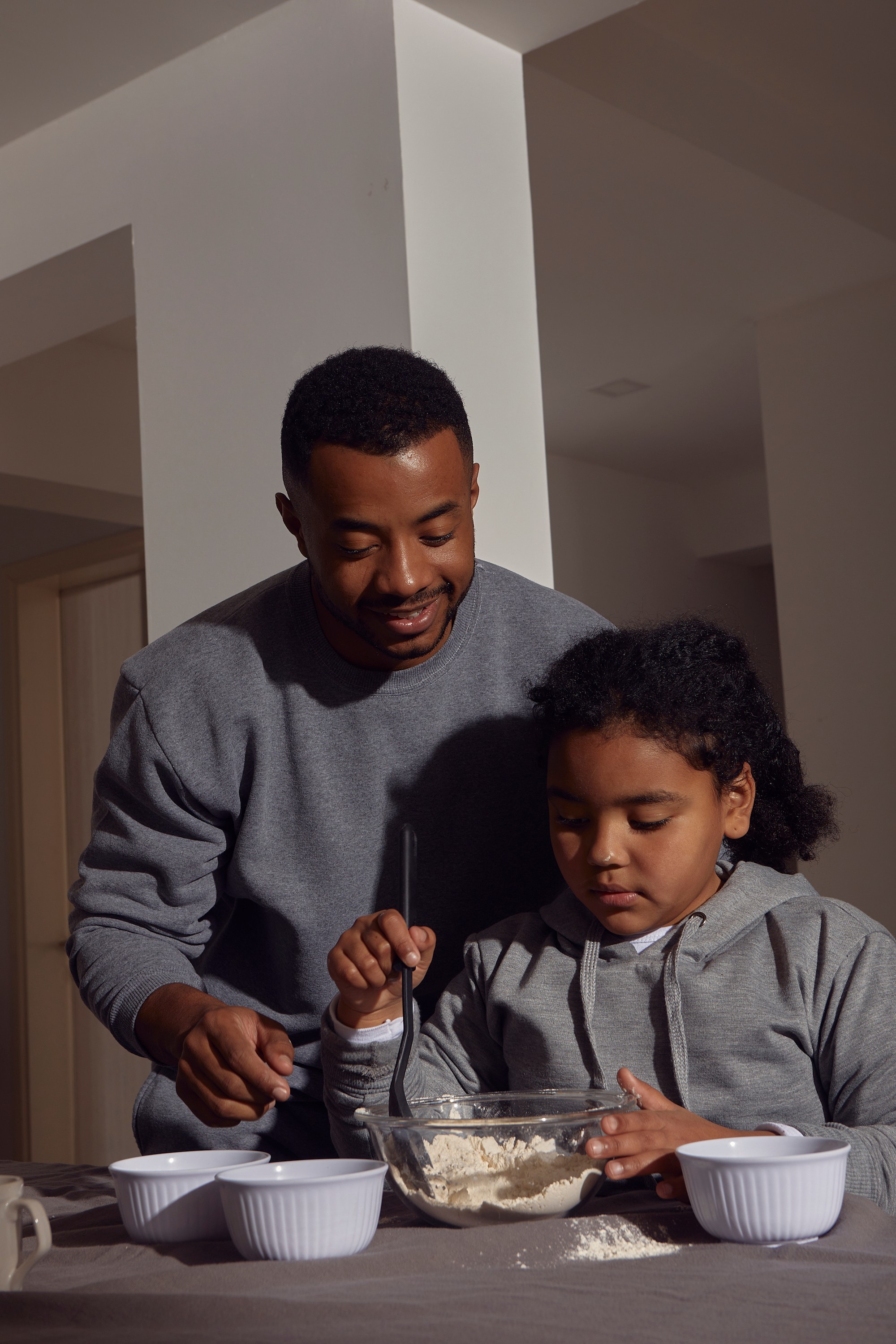 A father and daughter mix salad together
