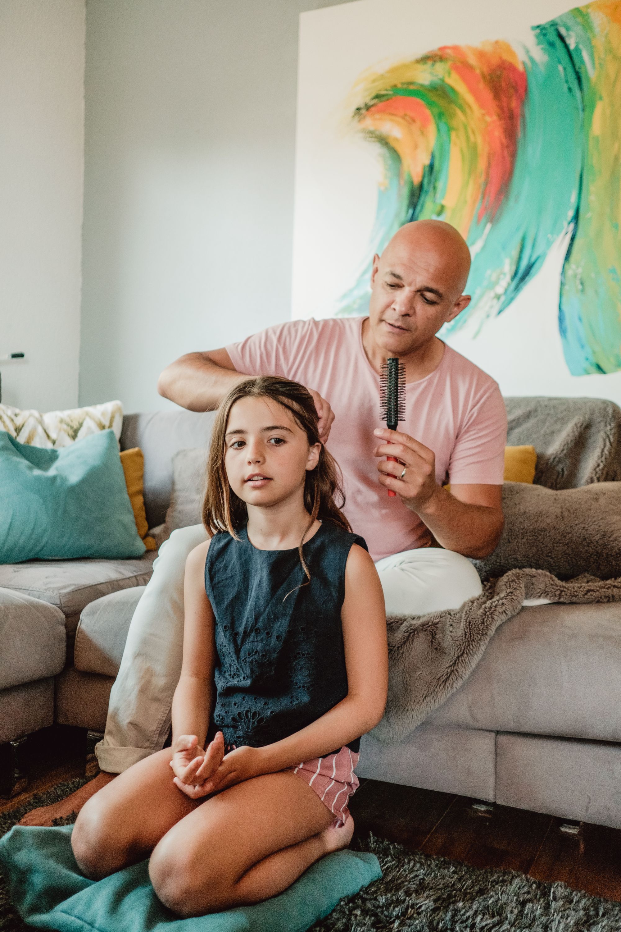 A father doing his daughter's hair