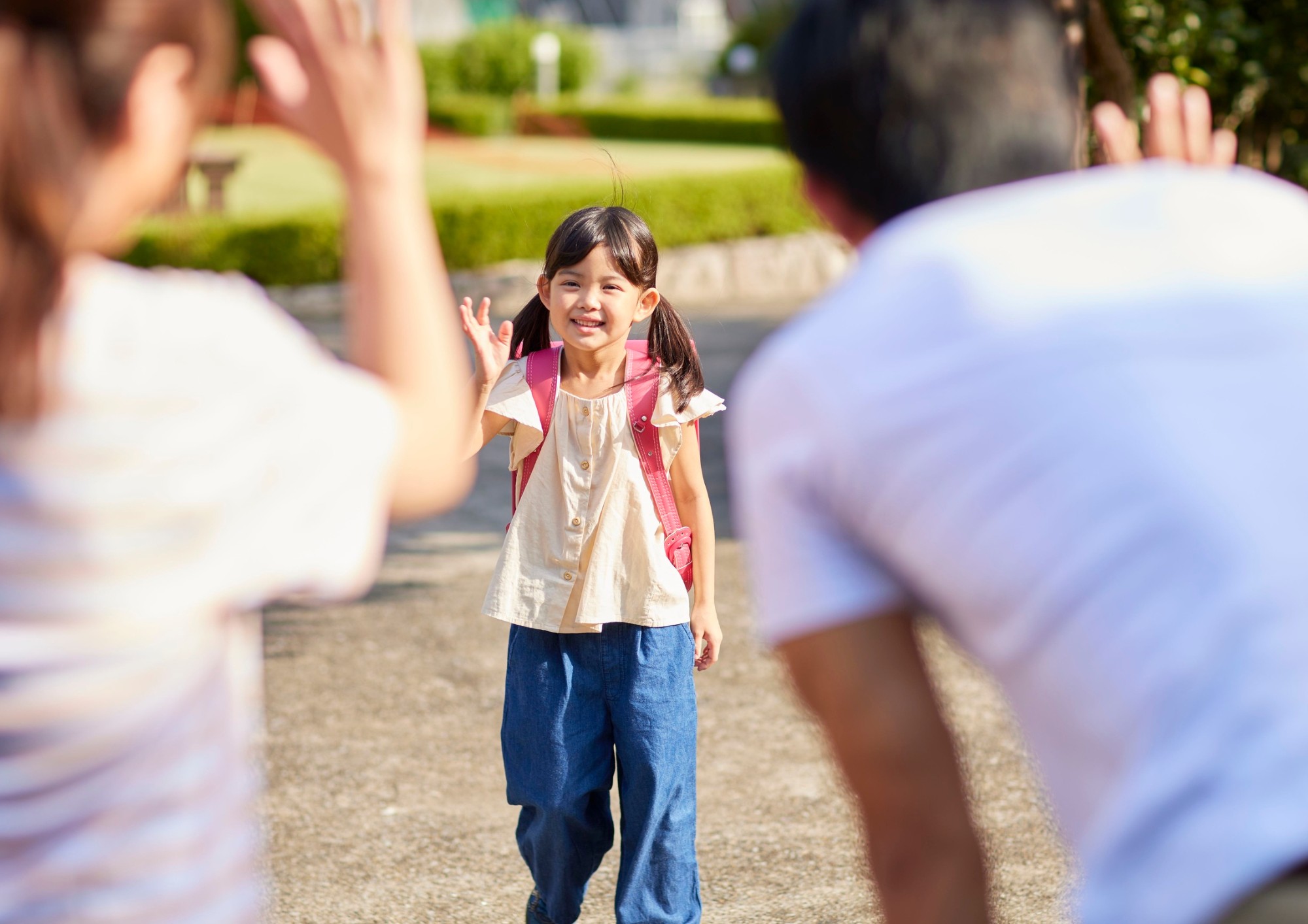 A girl waves goodbye