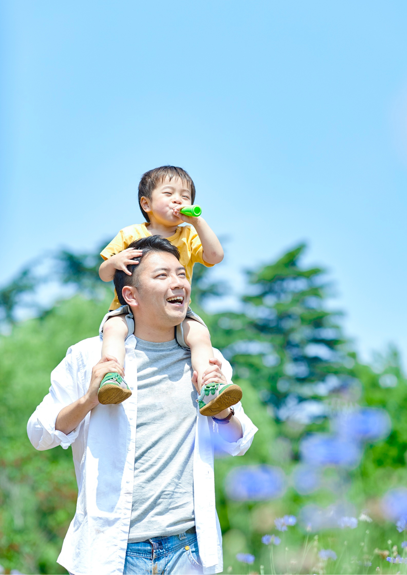 A child rides on their father's shoulders