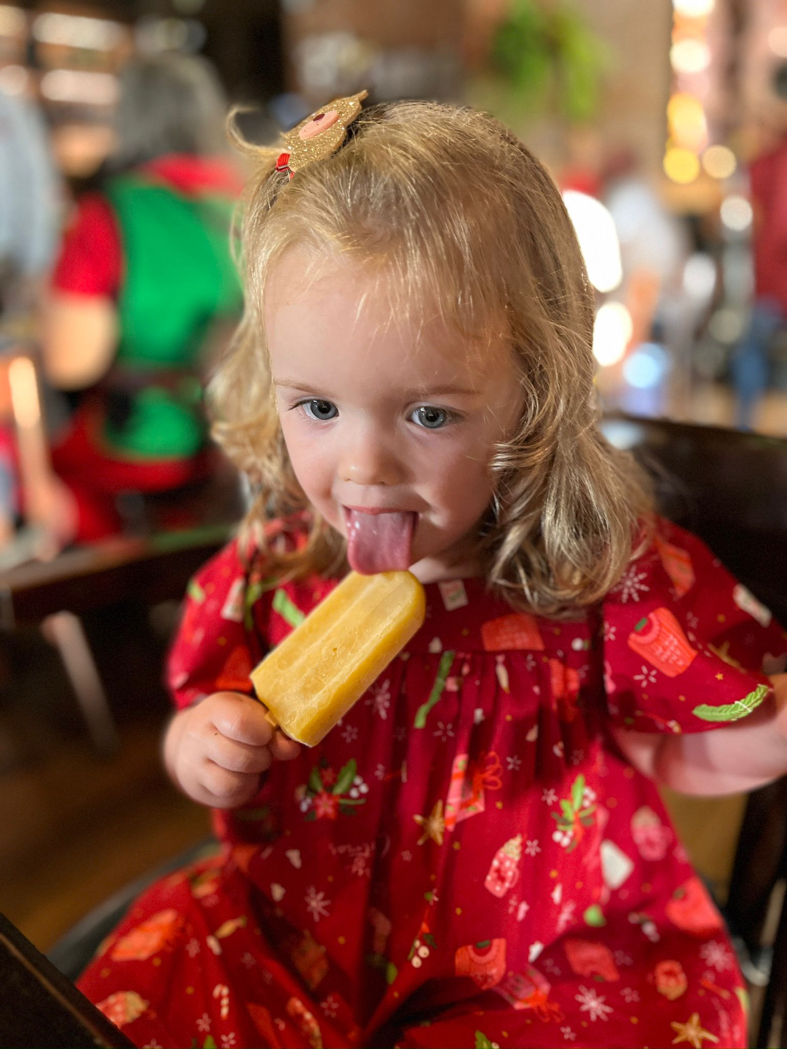 A white toddler enjoying a fresh fruit ice lolly at The Londoner pub in Bangkok 