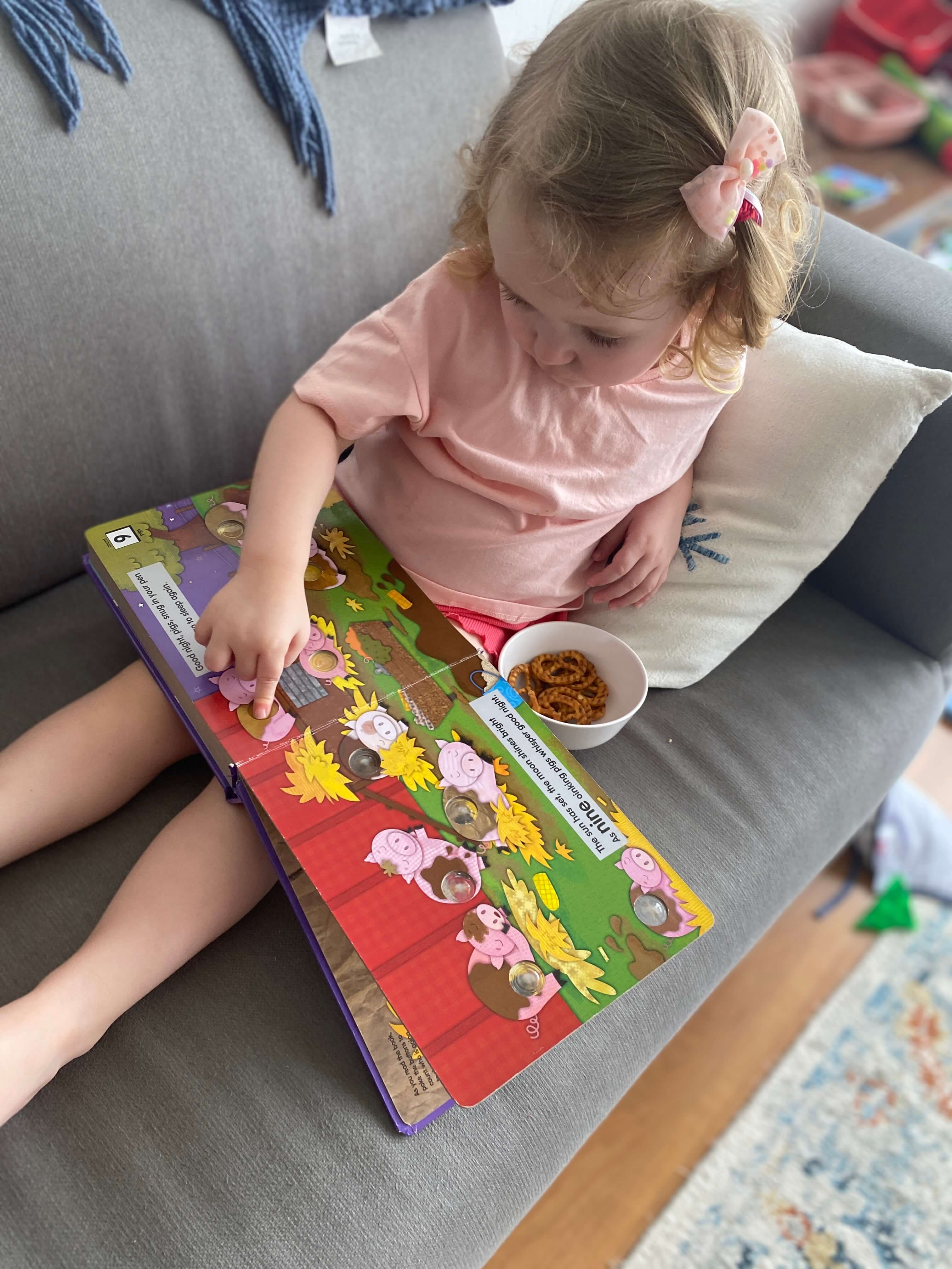 A child reading a Poke-A-Dot! Book