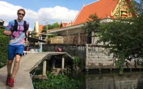 A white man running alongside a waterway in Bangkok, Thailand