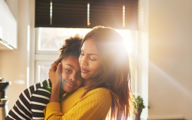 A Black mother and daughter hugging