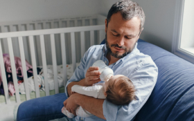 A father feeding his newborn baby