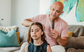 A dad doing his daughter's hair