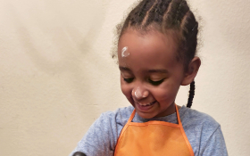 A girl stirs a bowl of flour