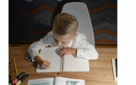 A child writes at a desk.