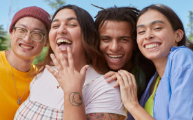 Four friends smile into the camera.