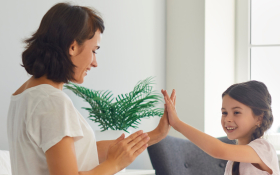 A mother and daughter high-five each other.