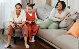 A family play a computer game on the couch.