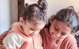 Two girls look at something together