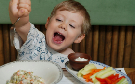 A child smiles happily over a full table