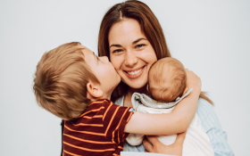 A mother hugs her two children