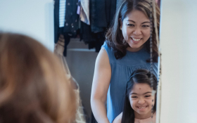 A mother and daughter look in a mirror