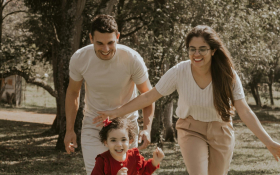 A mother and father walk with their child
