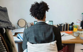 The back of a man sitting at a desk