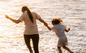 A mother and daughter run into the sea